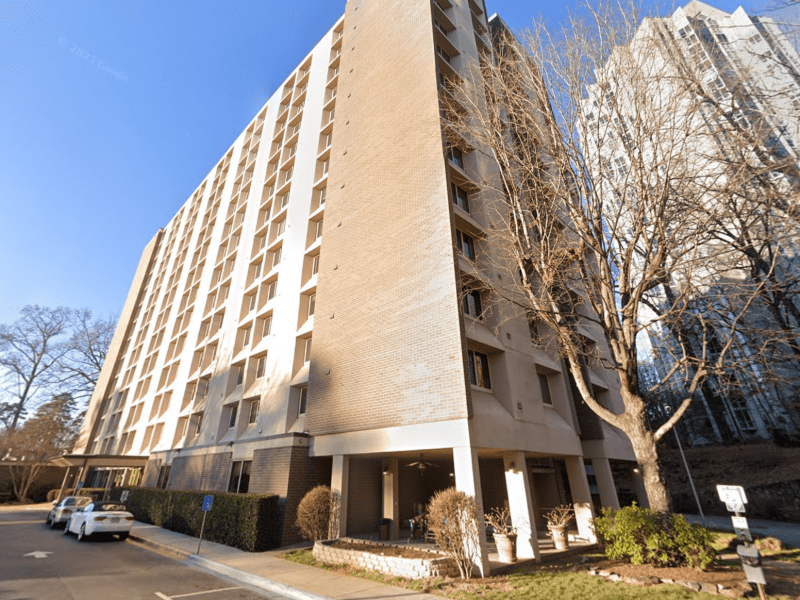 A photo of a tall, beige apartment building.