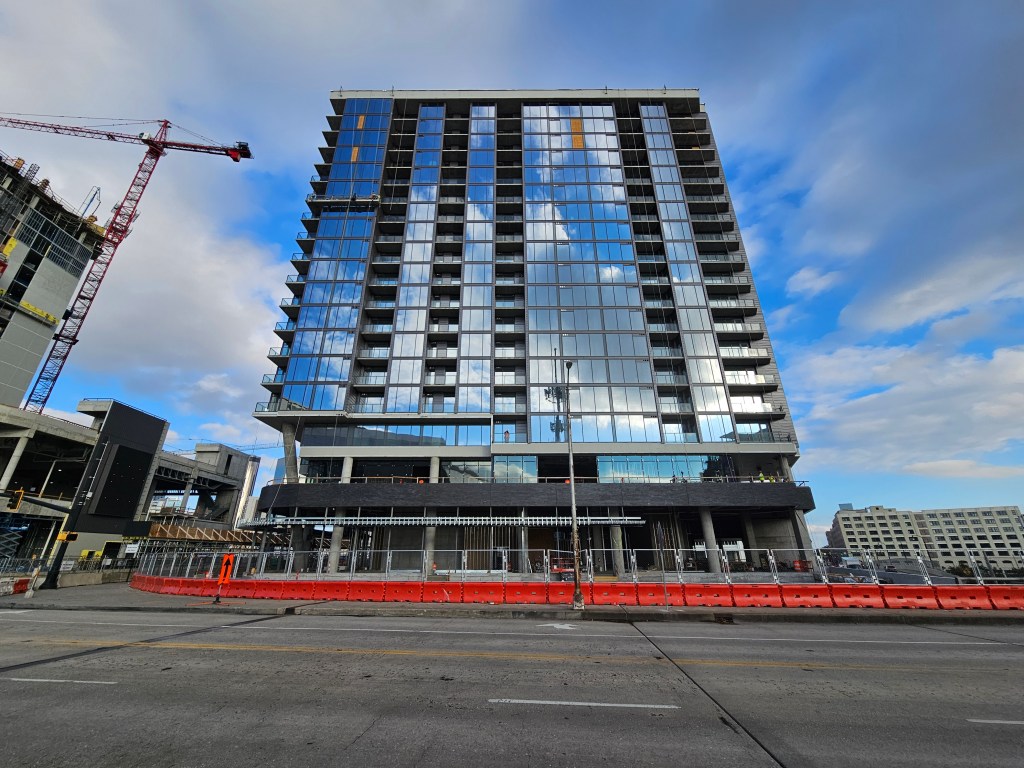 A photo of The Mitchell, a glassy high-rise being built downtown.