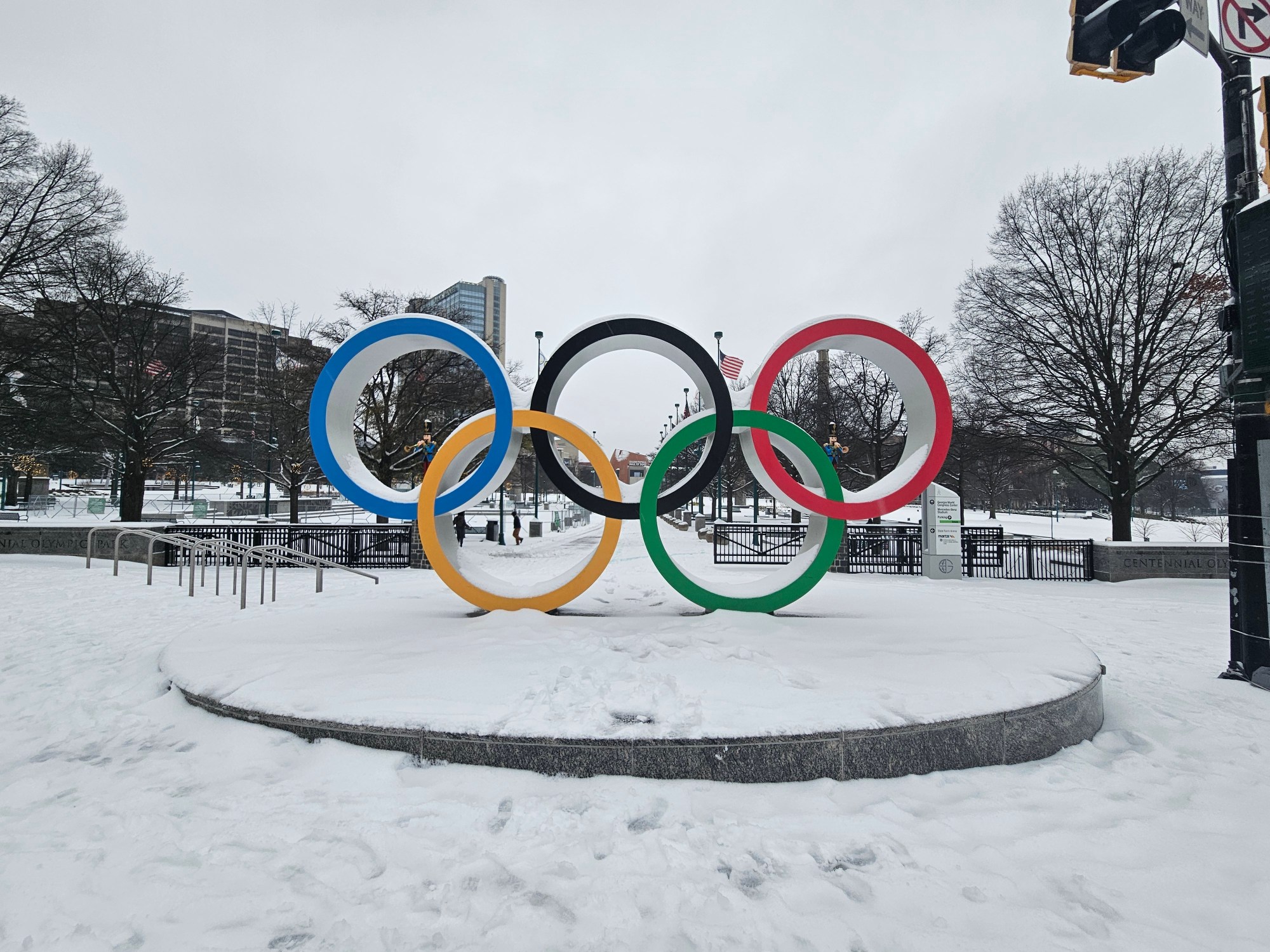 A photo of the Olympic Rings outside downtown's Centennial Olympic Park, surrounded by snow.