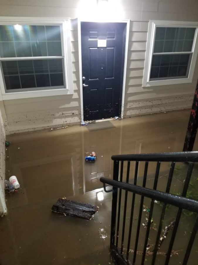 A photo of an apartment front door, surrounded by water.