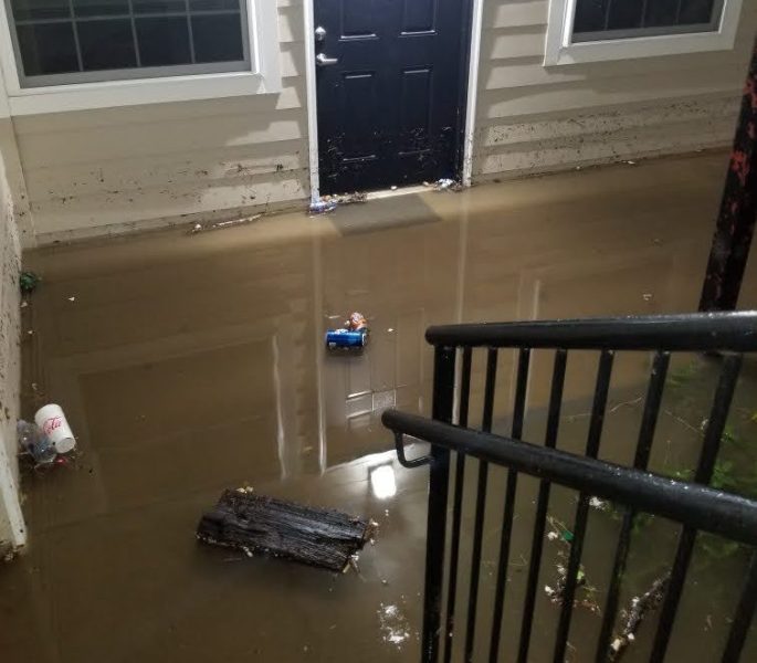 A photo of an apartment front door, surrounded by water.