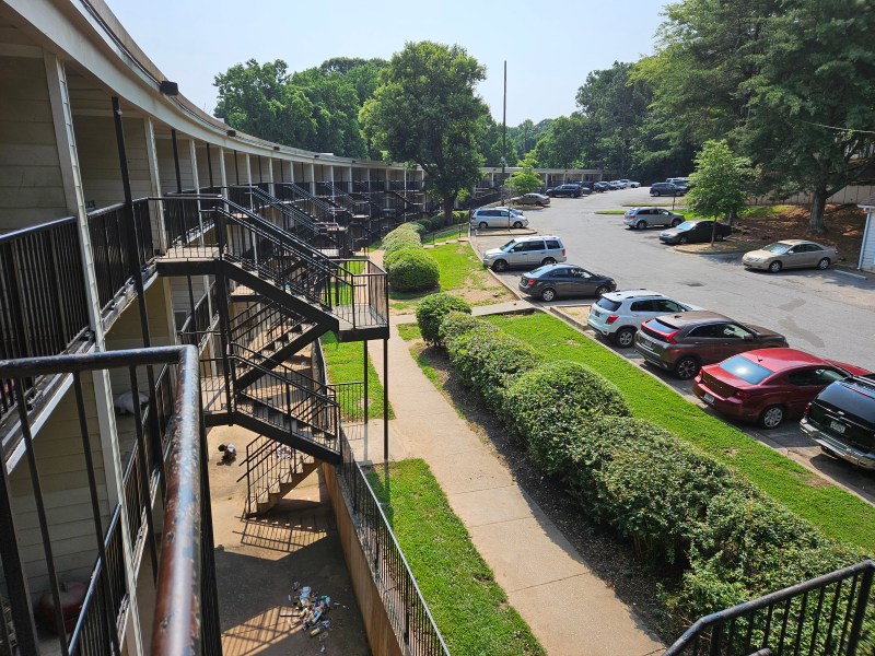 A photo of a curved four-story apartment building.