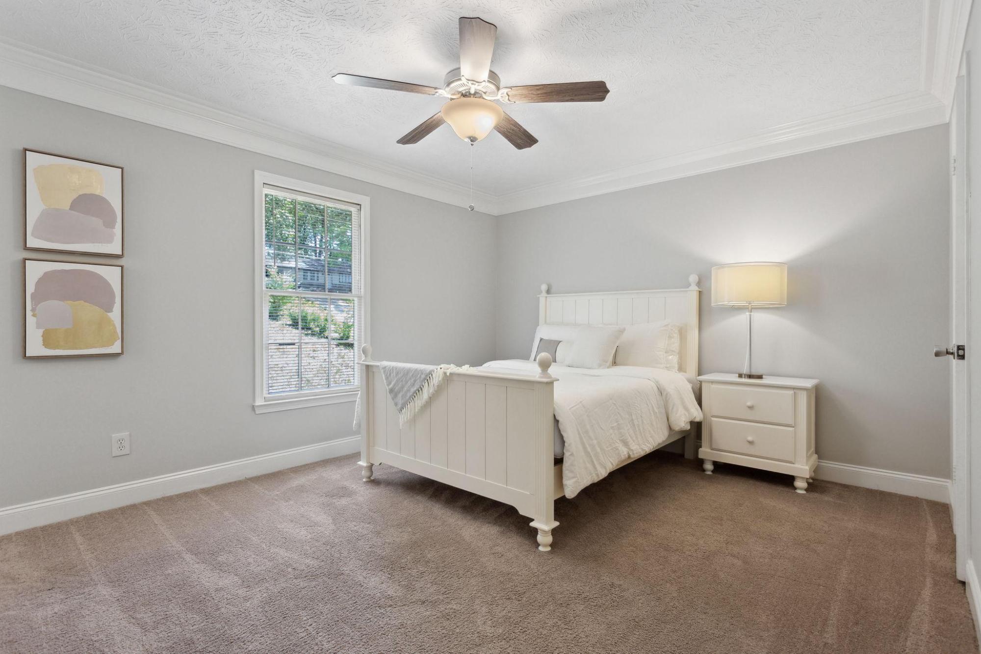 A photo of a PadSplit unit, with a bed at the center of a white room.