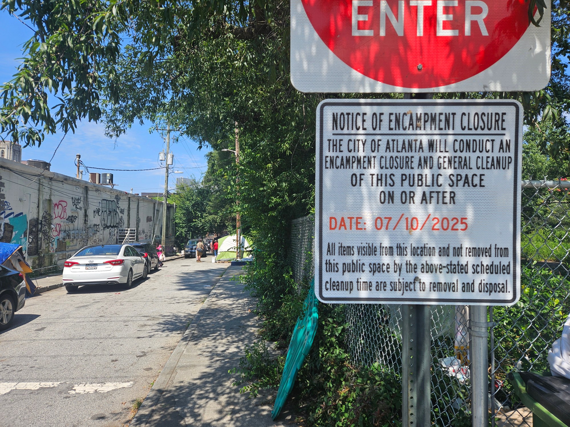 A photo of a sign warning of the impending homeless camp closure