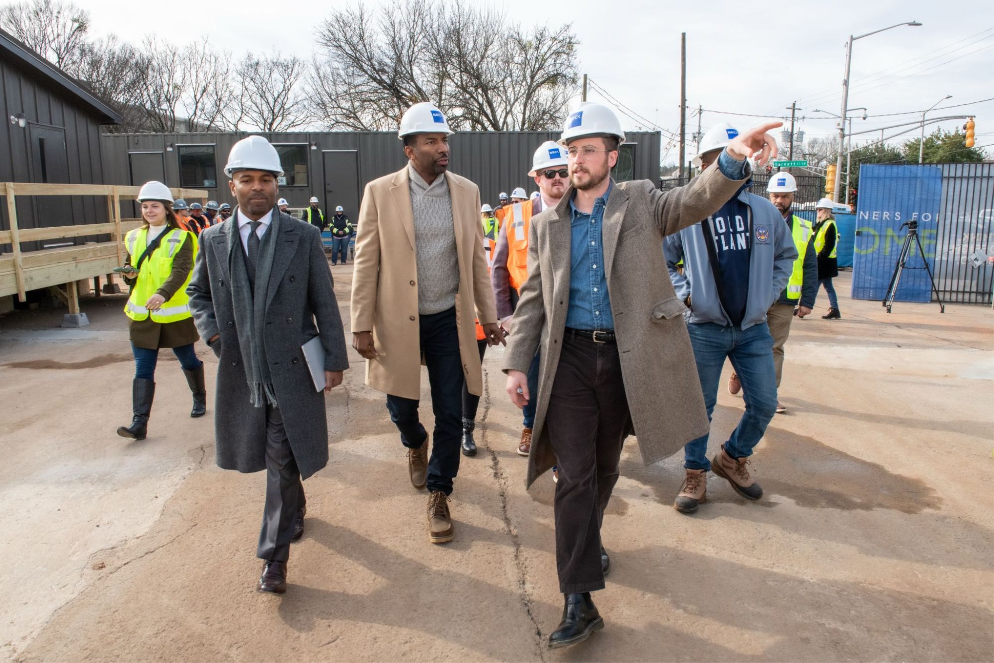 A photo of city officials and developers touring an affordable housing construction site.