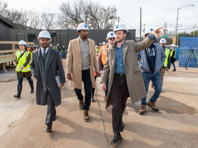 A photo of city officials and developers touring an affordable housing construction site.