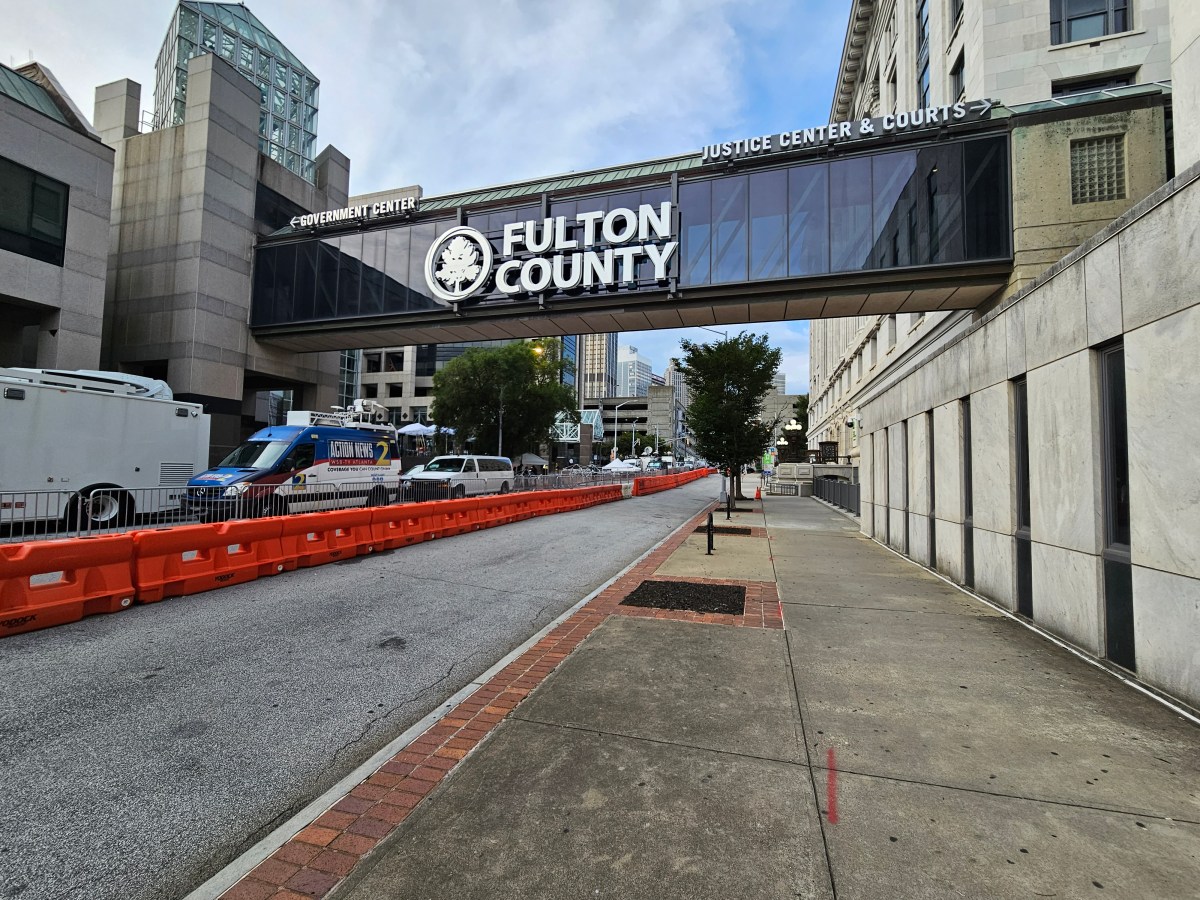 A skybridge arches over a city street. It says "Fulton County" in bold white letters.